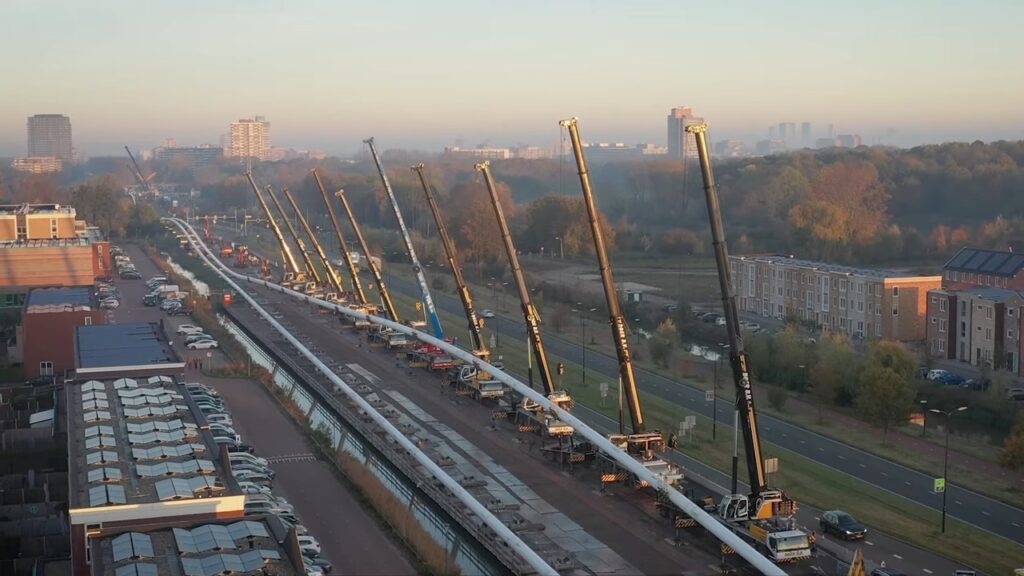 クレーン12台が横に並び白く細長いものを吊り上げる、その理由は