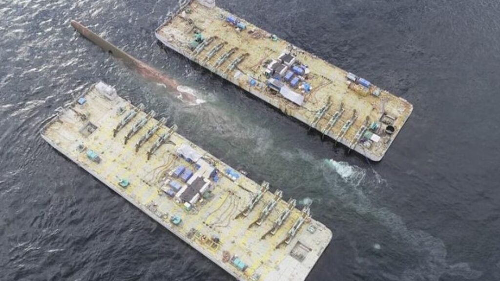 水深60mから引き揚げられた「白虎」の船底が海面に姿を現す